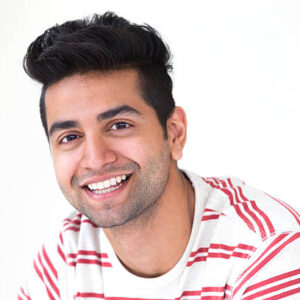 Portrait of young Asian man smiling at camera.